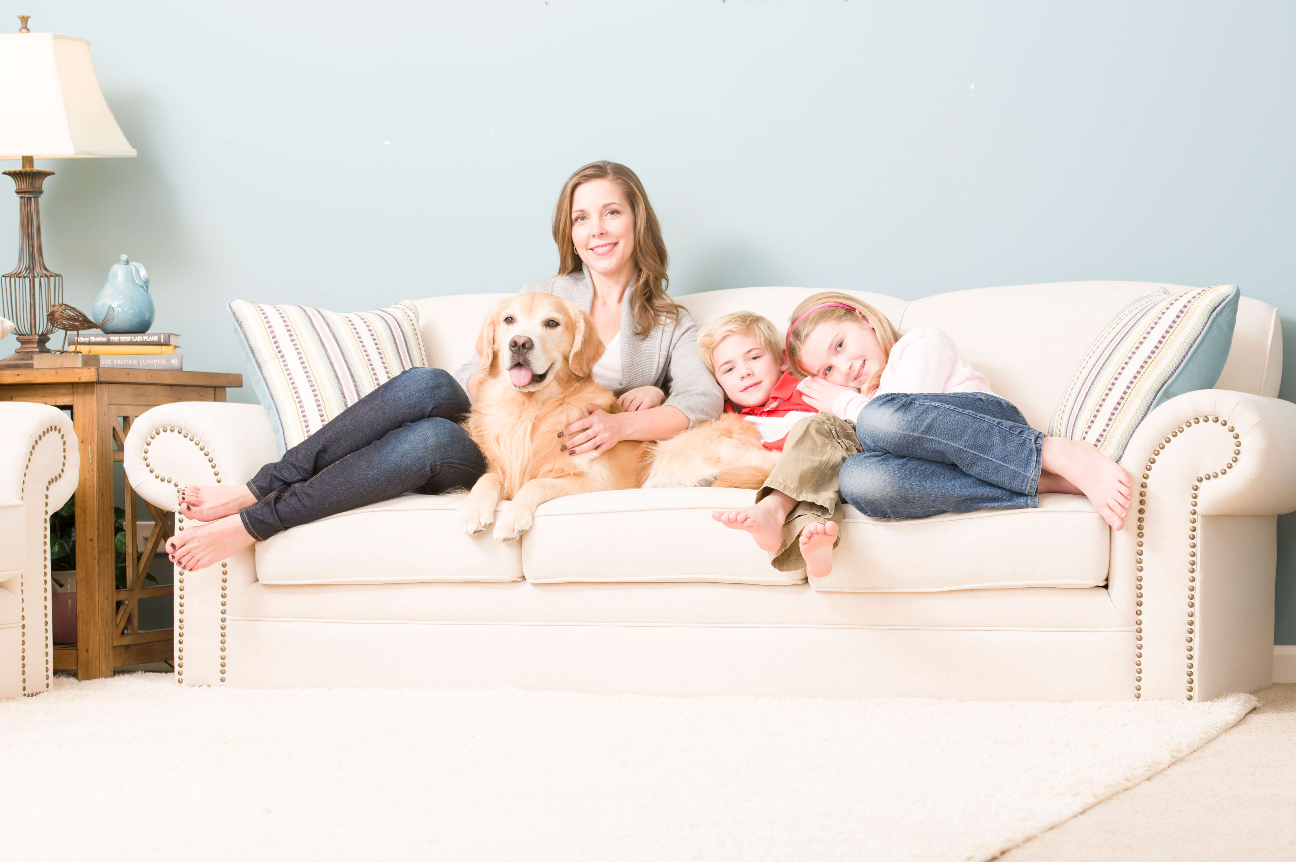 Photography by Bruce Starrenburg at Lightbox Studio family and dog sitting on clean couch